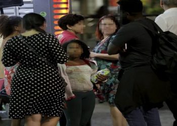 Menina oferece balas a quem passa pela Cinelândia, à noite, no Centro do Rio. (Foto: Domingos Peixoto - Divulgação)
