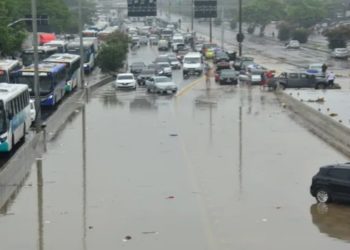 Pedestres e veículos de todos os tipos enfrentaram zona de alagamento na Avenida Brasil, altura do bairro do Irajá, zona norte do Rio de Janeiro, neste domingo (14) (Crédito: FAUSTO MAIA/THENEWS2/ESTADÃO CONTEÚDO
)