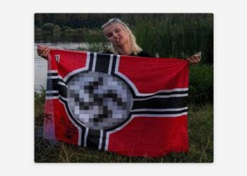 Escrivã de tribunal em Kiev é investigada após publicar foto com bandeira nazista; caso pode resultar em até cinco anos de prisão e confisco de bens.
