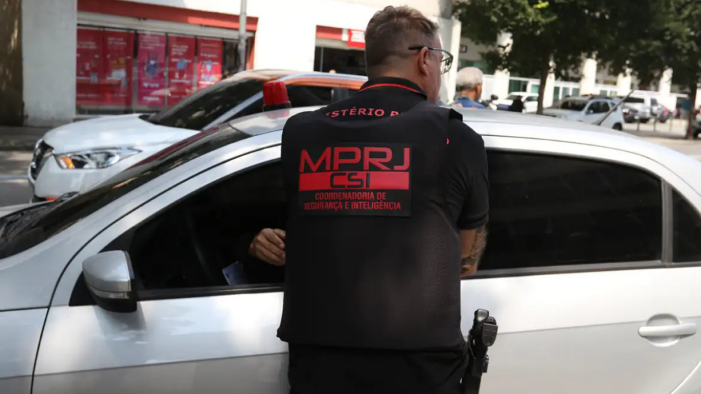 O Ministério Público do Rio denunciou três policiais militares por desvio de armas, tráfico de drogas e envolvimento com cargas roubadas, após investigação de milícia no Rio de Janeiro.