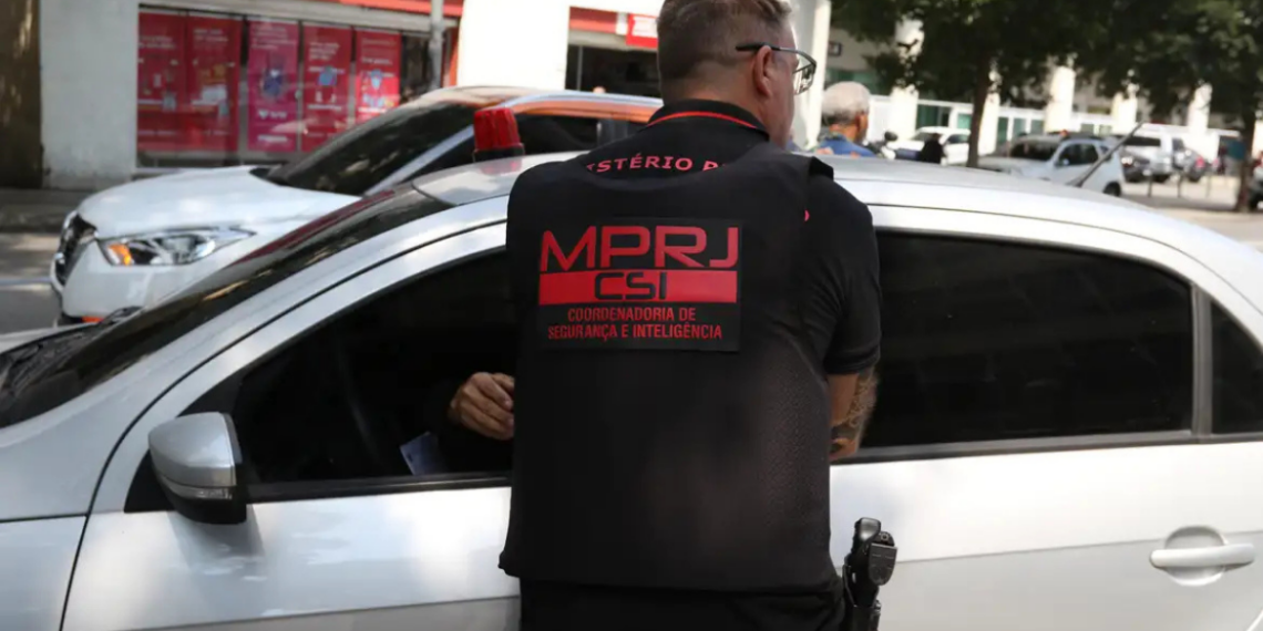 O Ministério Público do Rio denunciou três policiais militares por desvio de armas, tráfico de drogas e envolvimento com cargas roubadas, após investigação de milícia no Rio de Janeiro.