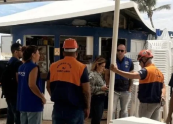 Fiscalização na Praia do Peró, em Cabo Frio, interdita três estabelecimentos após encontrar alimentos vencidos, falhas de higiene e riscos de incêndio.