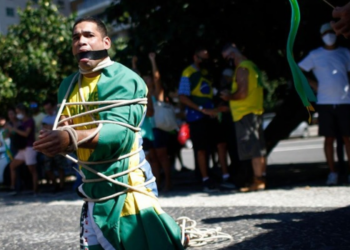 Vídeo gravado no Rio mostra manifestante conduzindo homem negro por corrente durante ato de Flávio Bolsonaro. Veja o que se sabe.