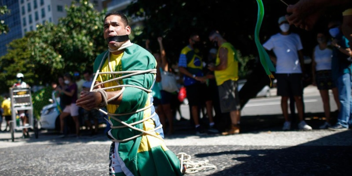 Vídeo gravado no Rio mostra manifestante conduzindo homem negro por corrente durante ato de Flávio Bolsonaro. Veja o que se sabe.